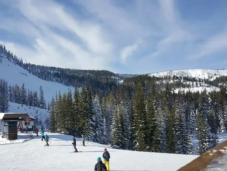 Skiers and snowboarders at the base of a chairlift at Lost Trail Powder Mountain