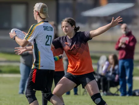 BHAA Hawks player tracking the disc as a defender closes in
