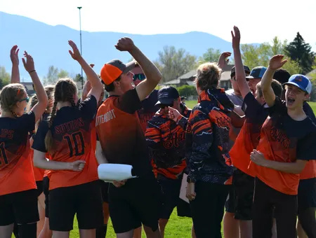 BHAA Hawks team huddled with arms raised in celebration after a game